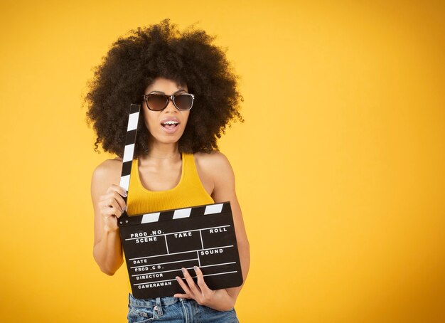 Femme regardant un film avec un clap