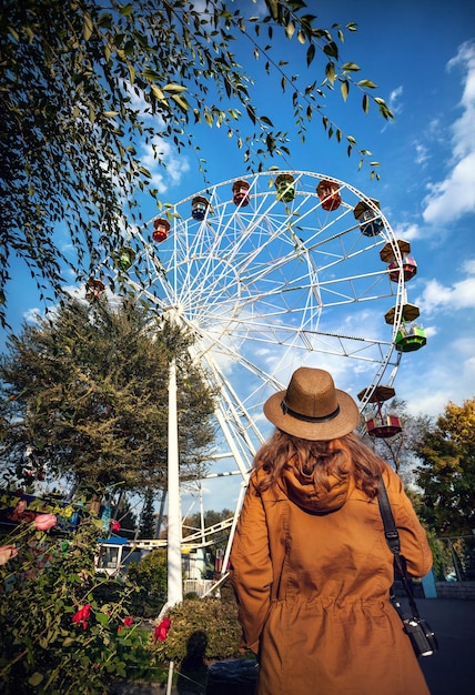 Photo femme regardant la grande roue dans le parc