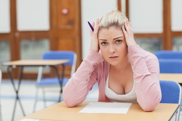 Photo femme regardant inquiète sur le papier d'examen