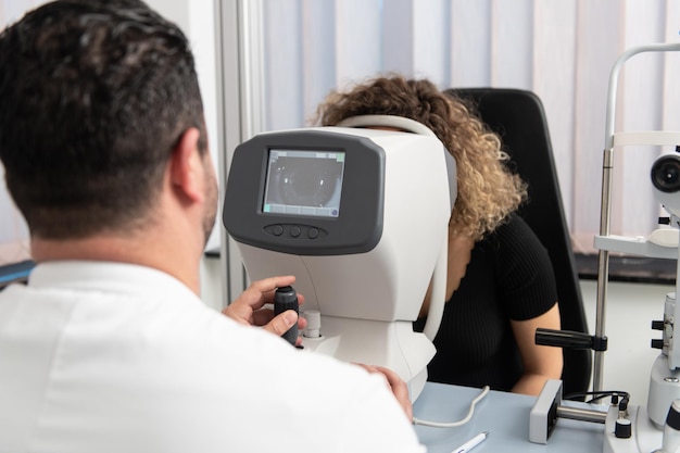 Femme regardant la machine de test oculaire réfractomètre en ophtalmologie