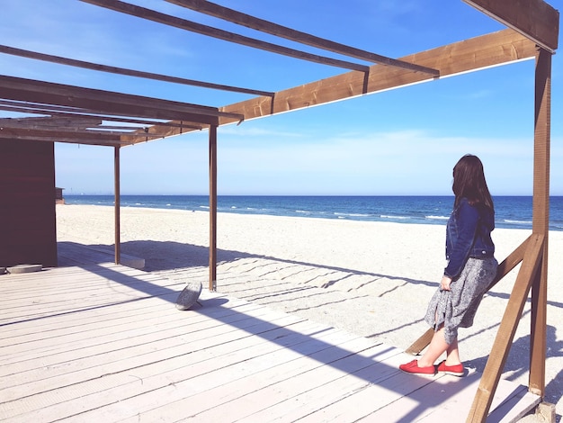 Une femme regardant la mer contre le ciel