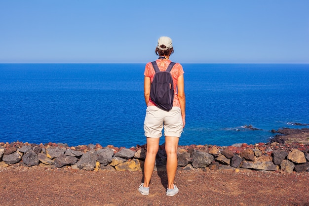 Femme regardant la mer depuis le sommet du volcan appelé Monte Nero, Linosa. Sicile. Italie