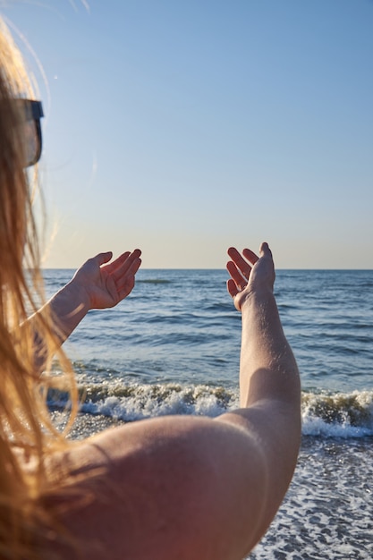 Femme regardant la mer, l'océan, de dos, nu avec des cheveux venteux.