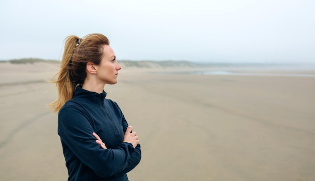 Femme regardant la mer sur la plage en automne