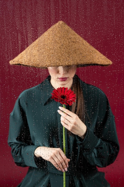 Femme regardant par la fenêtre un jour de pluie