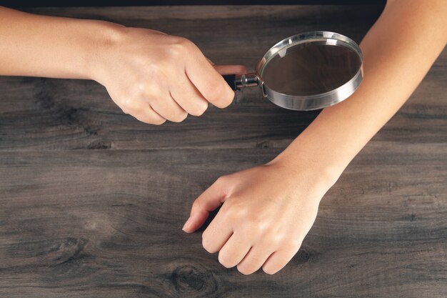 Femme regardant la peau avec une loupe