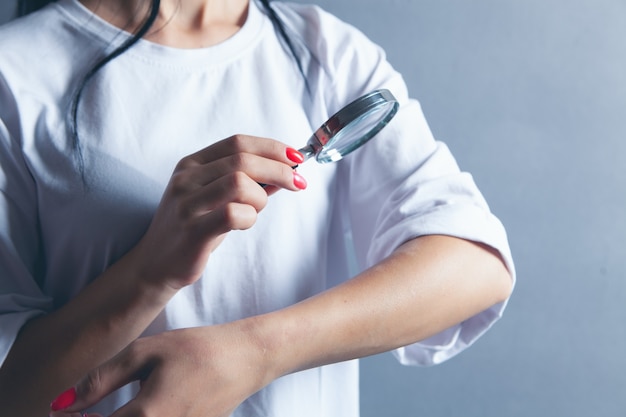 Femme regardant sa main avec une loupe