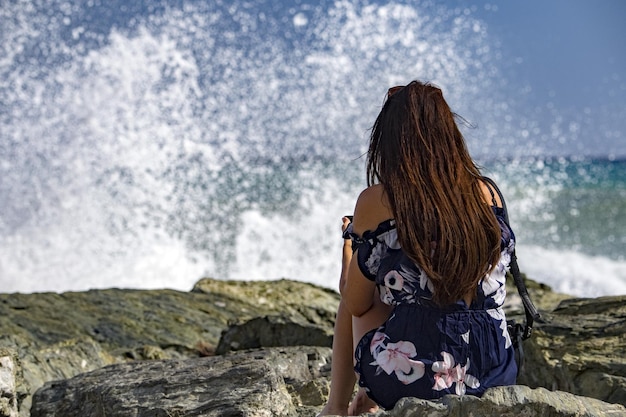 Femme regardant la tempête de mer sur la côte