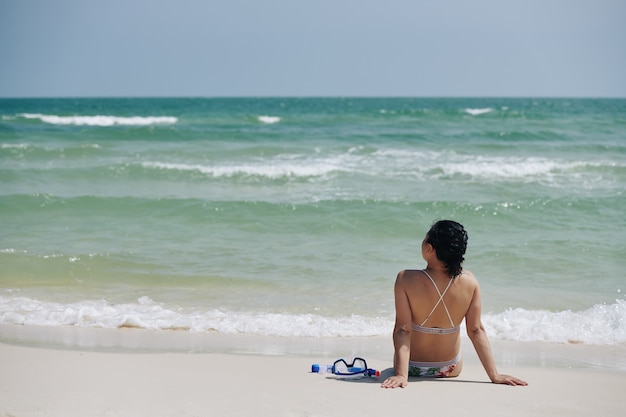 Femme regardant les vagues de la mer