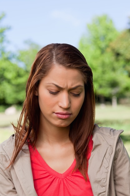 Femme regardant vers le bas avec une expression déçue sur son visage