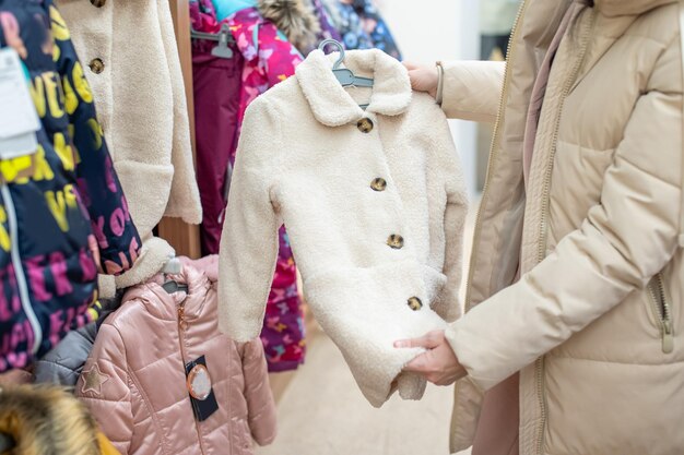 Une femme regarde les affaires des enfants dans un magasin