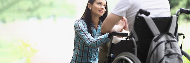 La femme regarde avec amour l'homme en fauteuil roulant