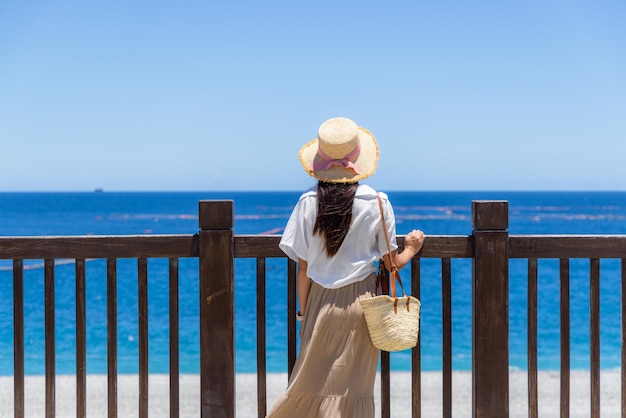 Femme regarde la mer bleue