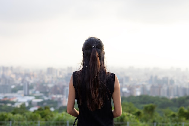 Femme regarde la ville sur la montagne