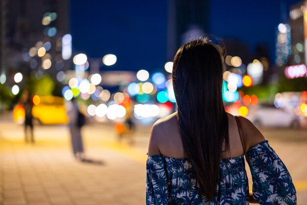 La femme regarde la ville de Taipei la nuit