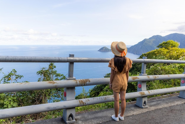 La femme regarde la vue sur la mer et se tient au sommet