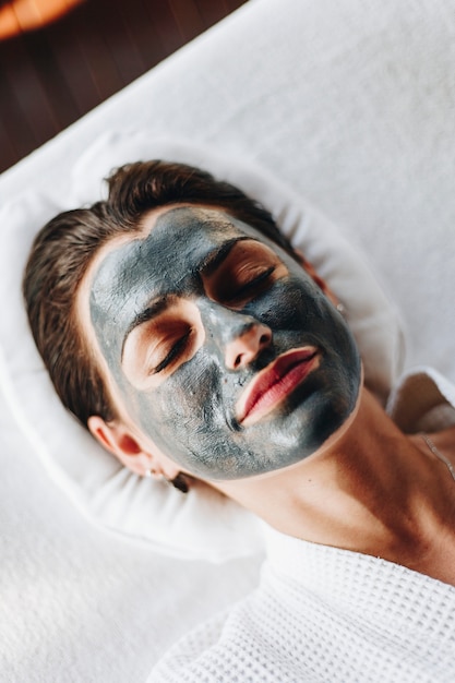 Femme relaxante avec un masque facial au spa