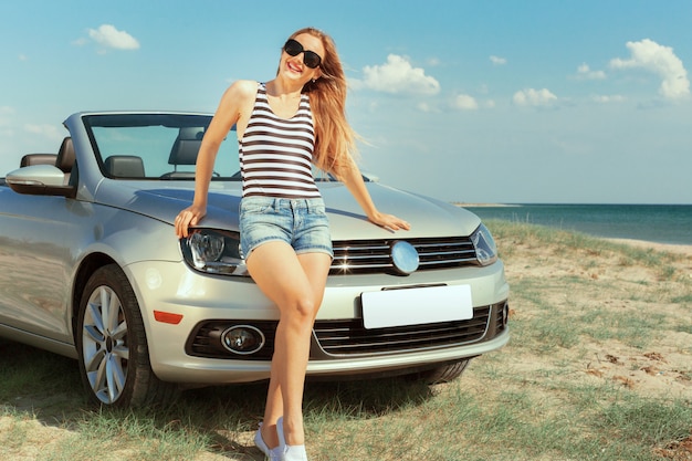 Femme relaxante sur la plage en voiture