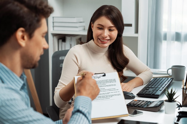 La femme remet une note de scénario au directeur pour examiner le postulat du message.