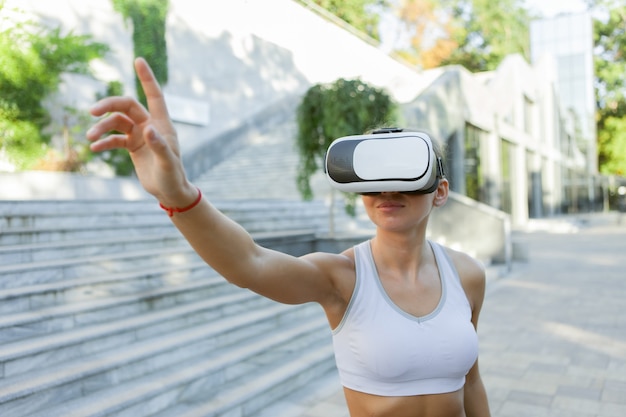 Femme de remise en forme avec un casque de réalité virtuelle à l'extérieur