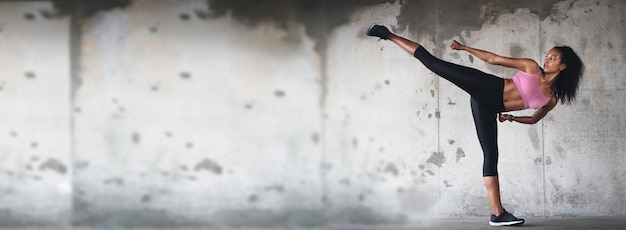 Photo femme de remise en forme et coup de pied de karaté sur la bannière pour le sport athlétique ou les arts martiaux en plein air pour l'entraînement ou l'exercice athlète d'entraînement et kickboxing pour le bien-être d'un corps sain ou cardio sur un espace de maquette