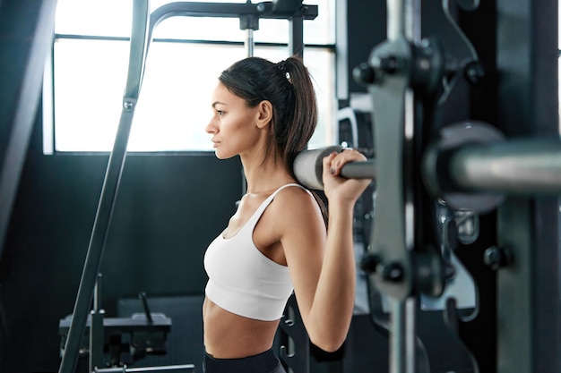 Femme de remise en forme effectuant un exercice avec une barre