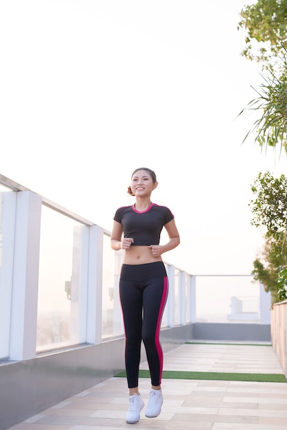 Femme de remise en forme, elle court la route.