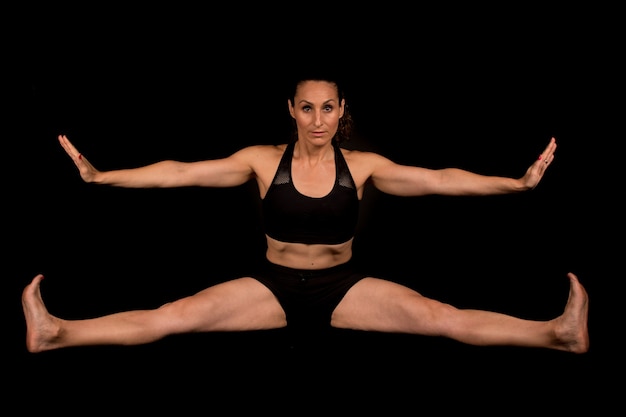 Femme de remise en forme qui s'étend des jambes et des bras