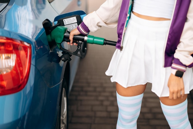 Photo femme remplissant sa voiture de carburant dans une station-service