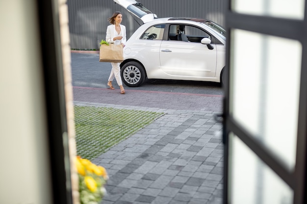 Femme rentrant à la maison avec l'épicerie