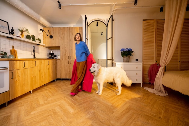 Une femme rentre à la maison avec son animal de compagnie qui l'attend