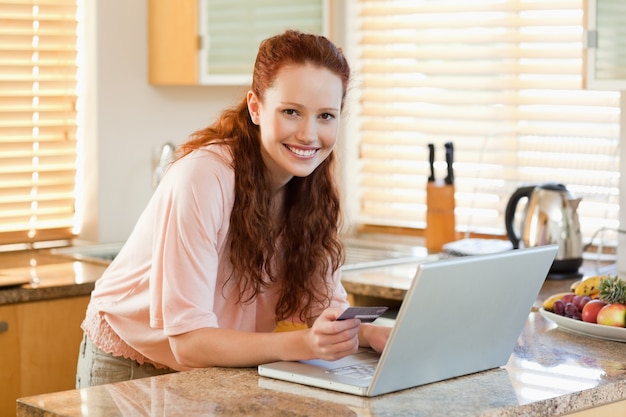 Femme réservation vol en ligne dans la cuisine