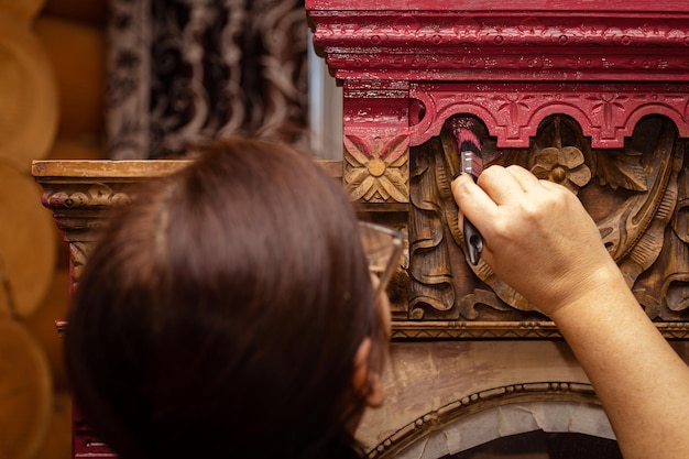 Femme restaurant de manière créative une armoire en bois antique avec des ornements sculptés à la main Réutilisation de vieux meubles pour un avenir durable Passe-temps de restauration de meubles