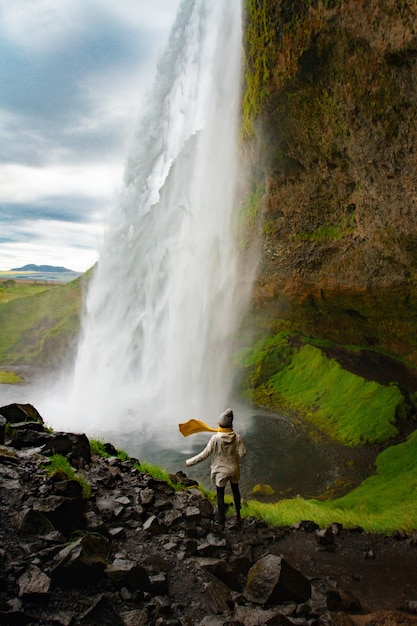 Femme rester sur une cascade en Islande cacher une cascade en Islande un