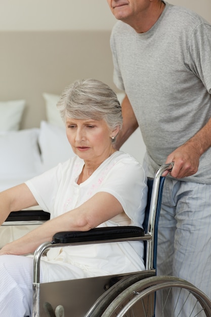 Femme à la retraite dans son fauteuil roulant avec son mari