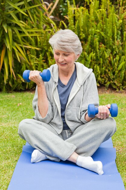 Femme à la retraite, faire ses exercices dans le jardin