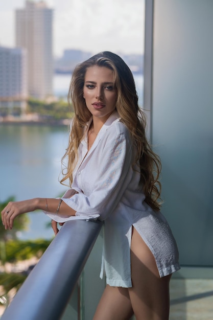 Une femme riche qui profite d'une matinée sur le balcon d'un appartement de luxe à Miami. Un concept de vie de luxe sexy.