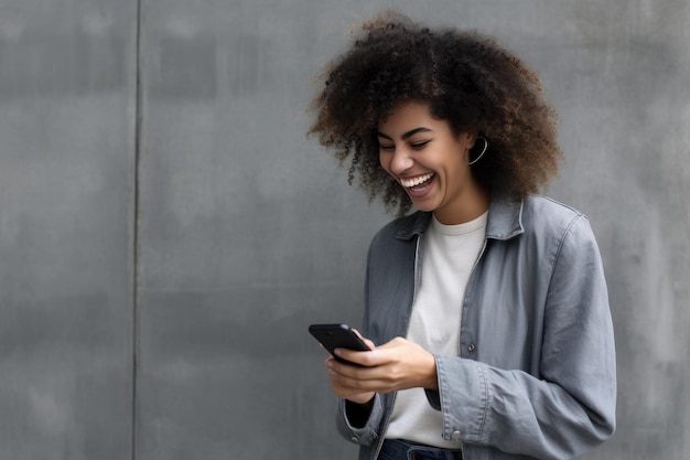 Une femme rit et tient un téléphone.