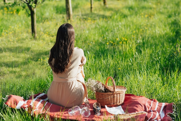 femme en robe assise dans le parc au jour d'été ensoleillé