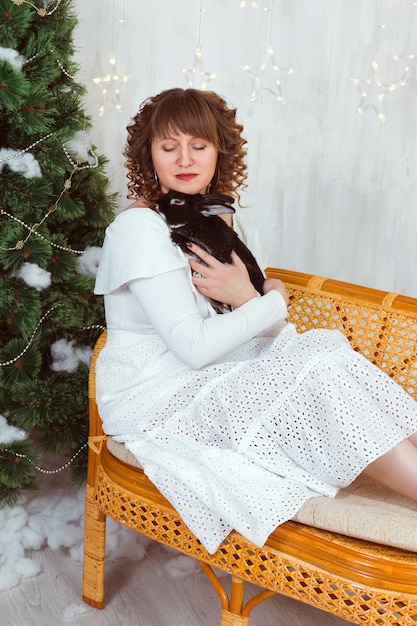 Une femme en robe blanche embrasse un lapin noir La relation d'une personne avec un animal de compagnie