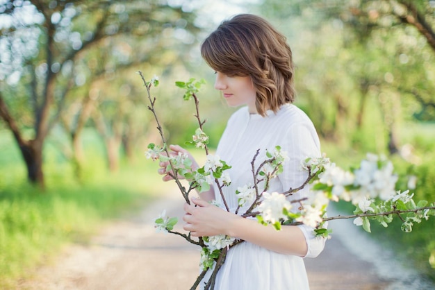 Femme en robe blanche jardin de printemps