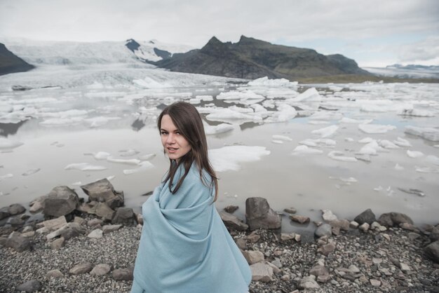 Femme en robe blanche se dresse sur fond de glaciers en Islande