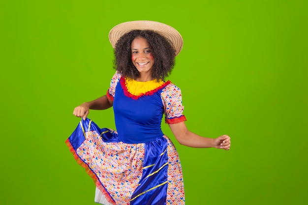 Une femme en robe bleue danse avec un chapeau de paille.