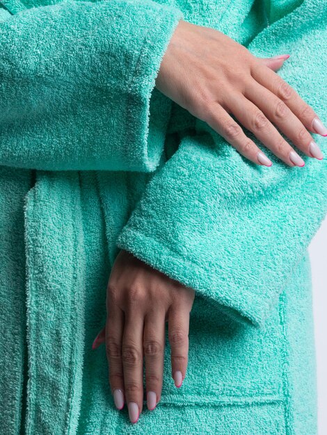 Femme en robe de chambre lumineuse annonce les détails des vêtements sur un fond blanc isolé