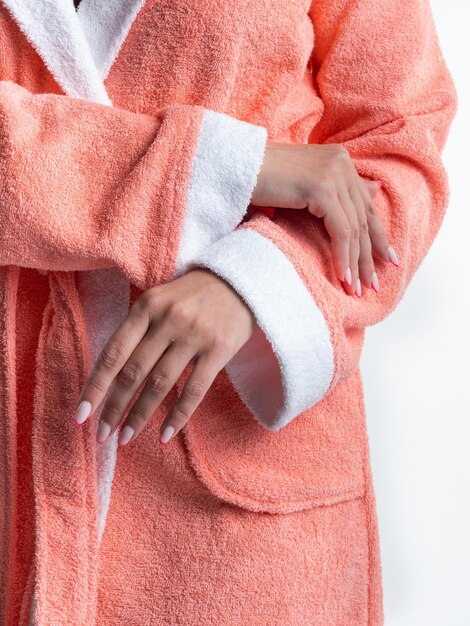 Femme en robe de chambre lumineuse annonce les détails des vêtements sur un fond blanc isolé