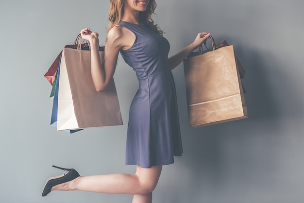 Femme En Robe De Cocktail Tenant Des Sacs à Provisions.