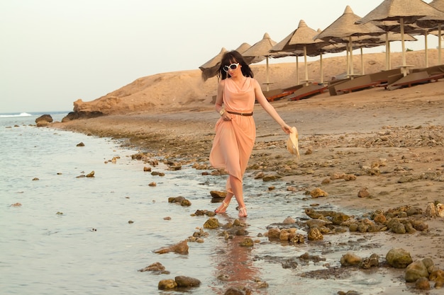 Femme en robe debout dans l'eau de mer