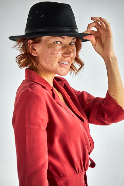 femme en robe élégante et chapeau posant à la caméra, les gens et le concept de mode de vie. jolie femme a