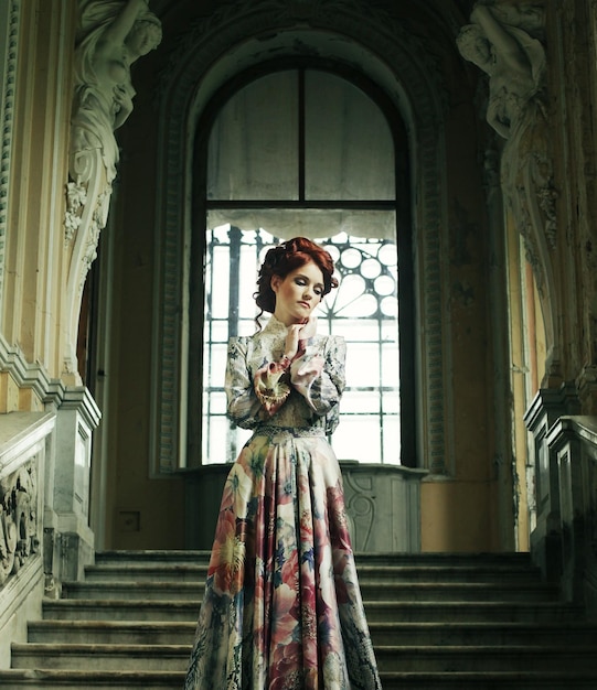 Photo une femme en robe élégante posant sur les escaliers