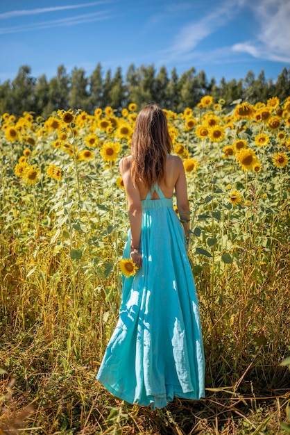 Femme en robe d'été embrassant la beauté des tournesols et l'espoir de paix